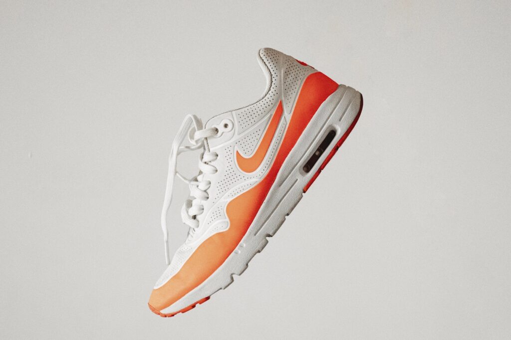 white and red nike athletic shoe