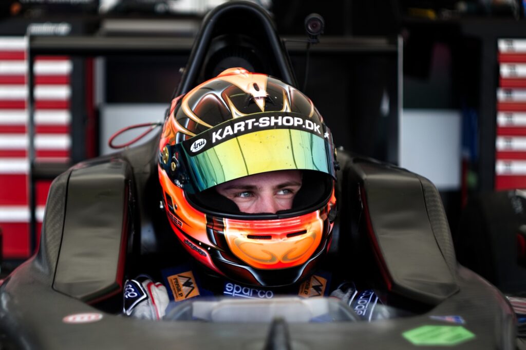 Young racedriver in his racing car befor the race.